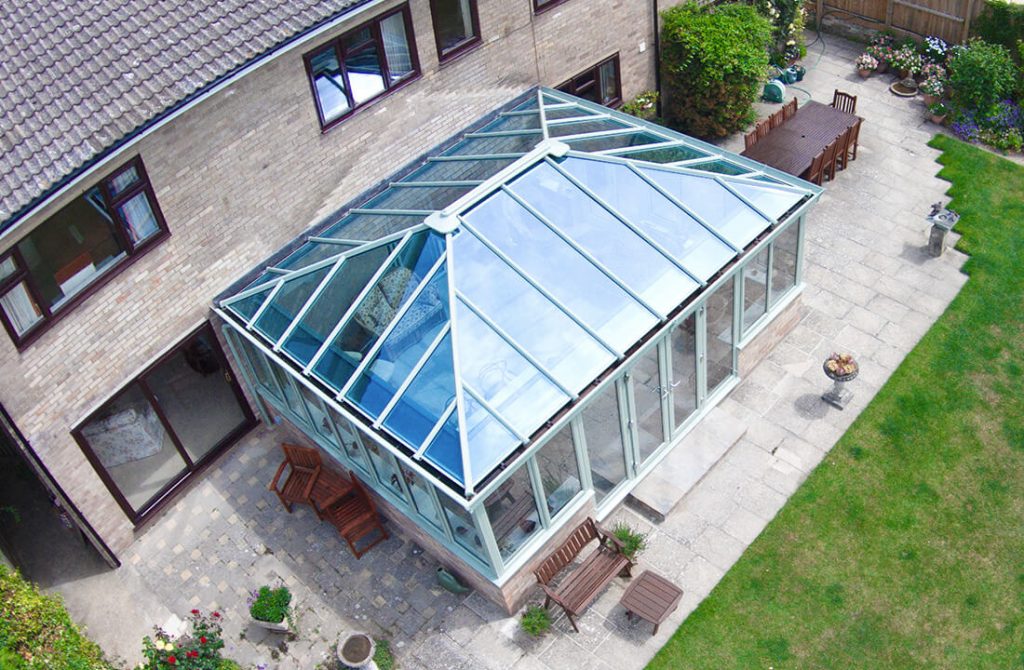 Green uPVC Edwardian conservatory with a glass roof